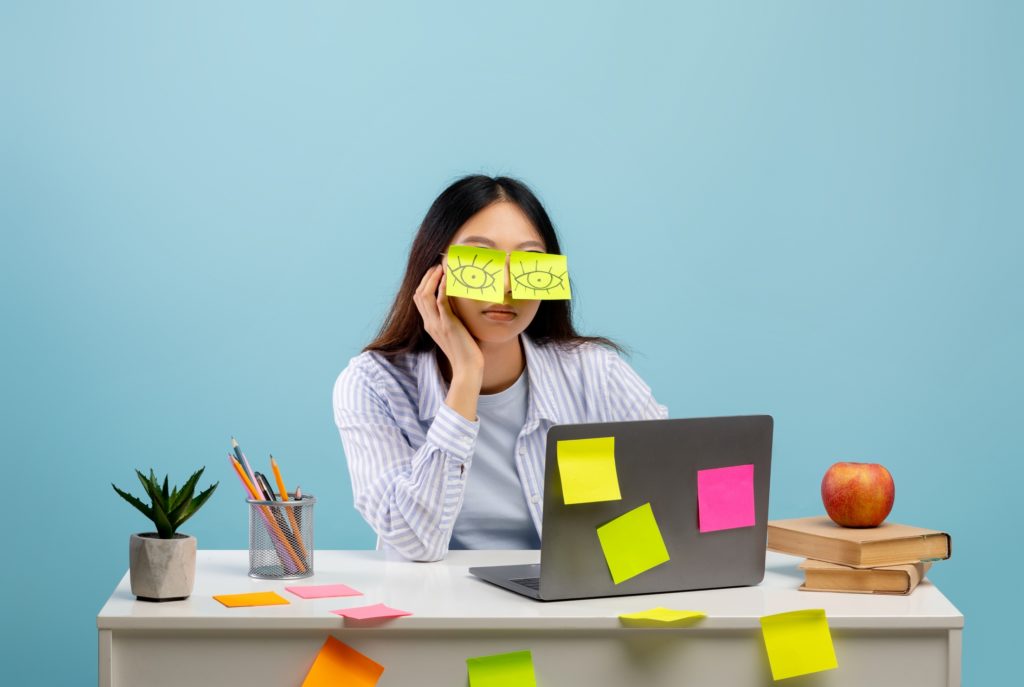 Young woman with post it notes covering her eyes